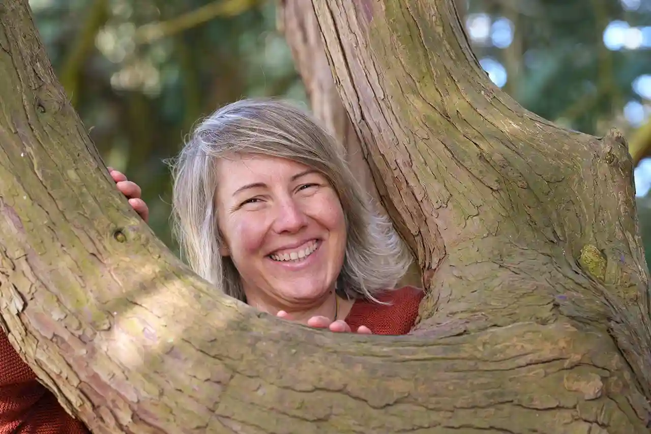 Andrea Kling lehnt an Baum und lächelt